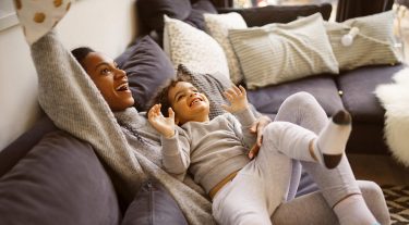 A mother and child play on a couch