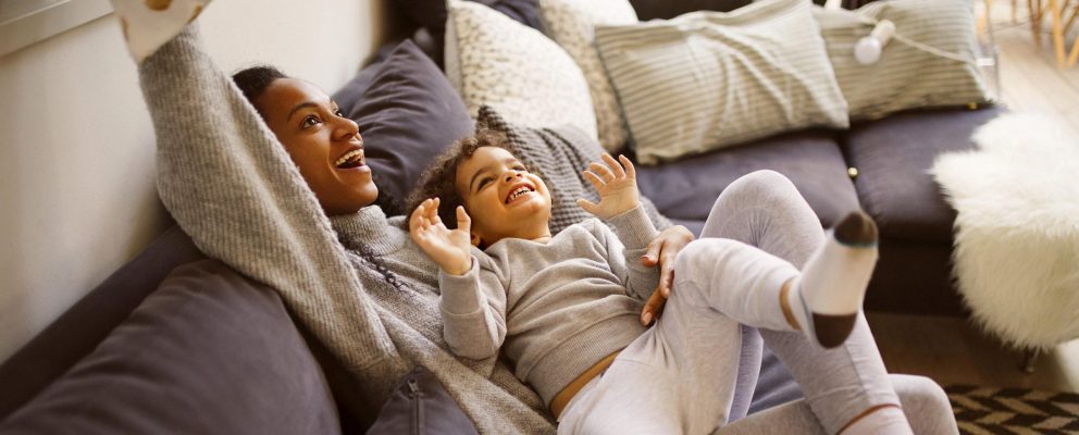 A mother and child play on a couch